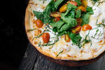 Close up Fresh italian pizza with tomatoes, cheese, basil on black wooden background. Copy space. Homemade with love. Fast delivery. Recipe and menu. Top view.