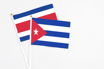 Cuba and Costa Rica stick flags on white background. High quality fabric, miniature national flag. Peaceful global concept.White floor for copy space.