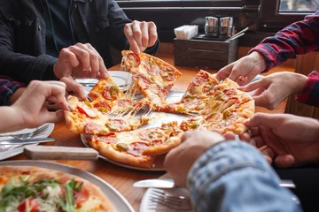 Foto op Canvas groep studentenvrienden eet Italiaanse pizza, handen nemen plakjes pizza in een restaurant © Богдан Маліцький
