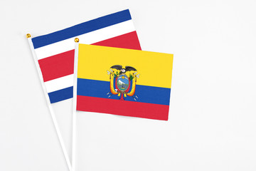 Ecuador and Costa Rica stick flags on white background. High quality fabric, miniature national flag. Peaceful global concept.White floor for copy space.