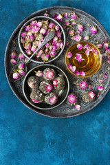 Composition with tea mug and rose buds on tray