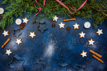 Christmas baking composition with cookies, cookies cutters, flour, spices and green fir branches on...