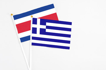 Greece and Costa Rica stick flags on white background. High quality fabric, miniature national flag. Peaceful global concept.White floor for copy space.