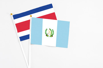 Guatemala and Costa Rica stick flags on white background. High quality fabric, miniature national flag. Peaceful global concept.White floor for copy space.