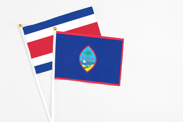 Guam and Costa Rica stick flags on white background. High quality fabric, miniature national flag. Peaceful global concept.White floor for copy space.