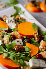 Salad with persimmon, rucola, mandarins, gorgonzola cheese, cran