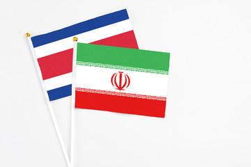 Iran and Costa Rica stick flags on white background. High quality fabric, miniature national flag. Peaceful global concept.White floor for copy space.