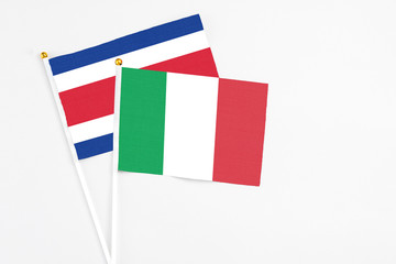 Italy and Costa Rica stick flags on white background. High quality fabric, miniature national flag. Peaceful global concept.White floor for copy space.