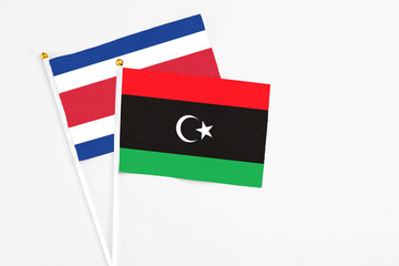 Libya and Costa Rica stick flags on white background. High quality fabric, miniature national flag. Peaceful global concept.White floor for copy space.
