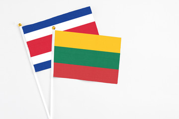 Lithuania and Costa Rica stick flags on white background. High quality fabric, miniature national flag. Peaceful global concept.White floor for copy space.