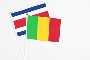 Mali and Costa Rica stick flags on white background. High quality fabric, miniature national flag. Peaceful global concept.White floor for copy space.