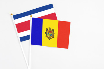 Moldova and Costa Rica stick flags on white background. High quality fabric, miniature national flag. Peaceful global concept.White floor for copy space.