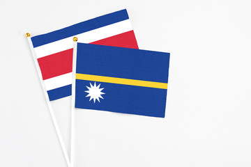 Nauru and Costa Rica stick flags on white background. High quality fabric, miniature national flag. Peaceful global concept.White floor for copy space.