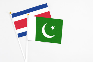 Pakistan and Costa Rica stick flags on white background. High quality fabric, miniature national flag. Peaceful global concept.White floor for copy space.