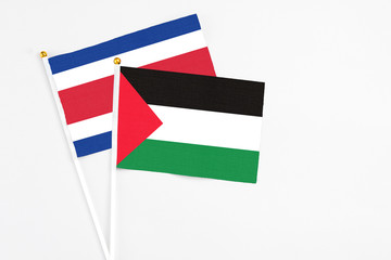 Palestine and Costa Rica stick flags on white background. High quality fabric, miniature national flag. Peaceful global concept.White floor for copy space.
