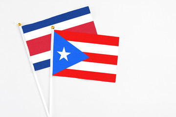 Puerto Rico and Costa Rica stick flags on white background. High quality fabric, miniature national flag. Peaceful global concept.White floor for copy space.