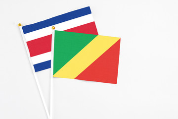 Republic Of The Congo and Costa Rica stick flags on white background. High quality fabric, miniature national flag. Peaceful global concept.White floor for copy space.