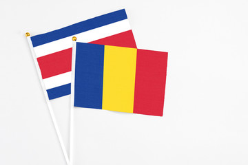 Romania and Costa Rica stick flags on white background. High quality fabric, miniature national flag. Peaceful global concept.White floor for copy space.