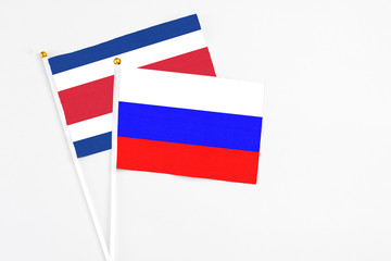 Russia and Costa Rica stick flags on white background. High quality fabric, miniature national flag. Peaceful global concept.White floor for copy space.