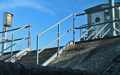 Fototapeta na wymiar Pier Staircase and Lock Monitoring House and Equipment on Sunny Day
