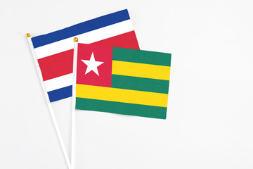 Togo and Costa Rica stick flags on white background. High quality fabric, miniature national flag. Peaceful global concept.White floor for copy space.