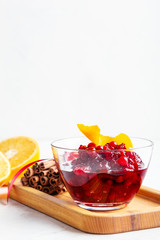 Thanksgiving cranberry sauce in glass bowl with fresh orange and lemon