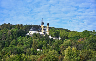 Fototapeta na wymiar Hillside Church with Onion Dome Bell Towers among Forest