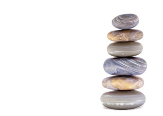 Fototapeta na wymiar Pile of spa stones on the table against a white background, space for text. Zen stones for meditation and mystical healing.