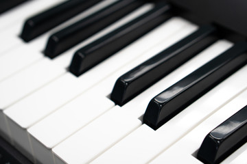 Closeup piano key on the wooden table with selective focus, electronic midi synthesizer keyboard for creative home studio