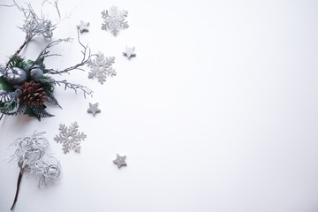 Christmas frame made of silver stars, snowflakes, cones, leaves and branches on white background. Winter concept. Flat lay, top view, copy space.Christmas composition.