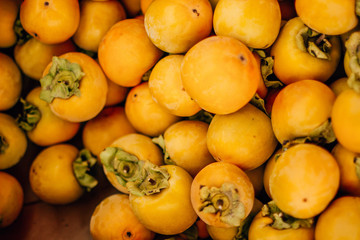 Naklejka na ściany i meble ripe tasty orange persimmon on the food market