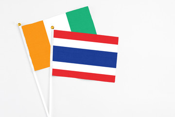 Thailand and Cote D'Ivoire stick flags on white background. High quality fabric, miniature national flag. Peaceful global concept.White floor for copy space.