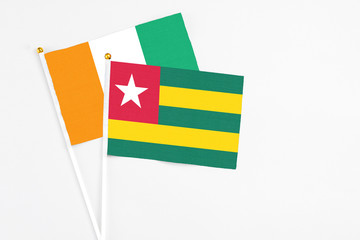 Togo and Cote D'Ivoire stick flags on white background. High quality fabric, miniature national...