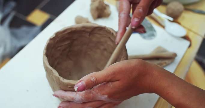 Hand made business online. Art education courses. Female sculptor artist teaching children. Closeup of woman hands modeling cley pot on pottery table. Performance inspire. Enjoying creative process.
