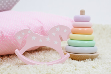 Children toys rainbow colored pyramid and pink toy horse on bright background