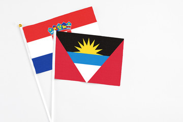Antigua and Barbuda and Croatia stick flags on white background. High quality fabric, miniature national flag. Peaceful global concept.White floor for copy space.
