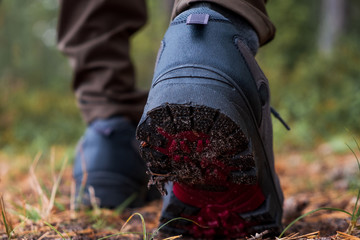 Close-ups of hiking shoes during a step in forest