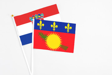 Guadeloupe and Croatia stick flags on white background. High quality fabric, miniature national flag. Peaceful global concept.White floor for copy space.