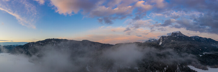 Fototapeta na wymiar colorful sunset sky panorama with clouds and mountains at austria pinswang