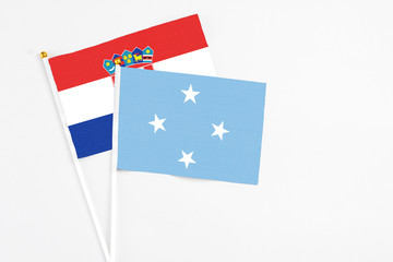 Micronesia and Croatia stick flags on white background. High quality fabric, miniature national flag. Peaceful global concept.White floor for copy space.