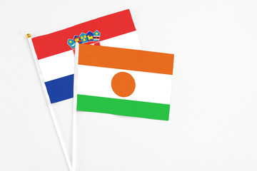 Niger and Croatia stick flags on white background. High quality fabric, miniature national flag. Peaceful global concept.White floor for copy space.