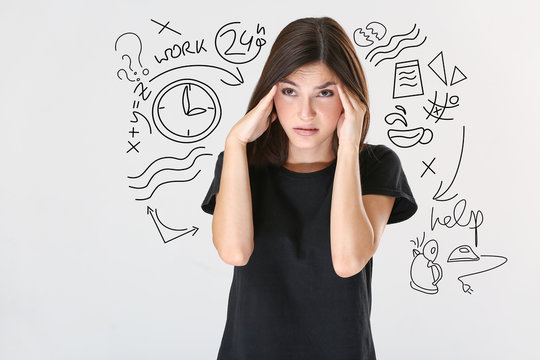 Stressed young woman on light background