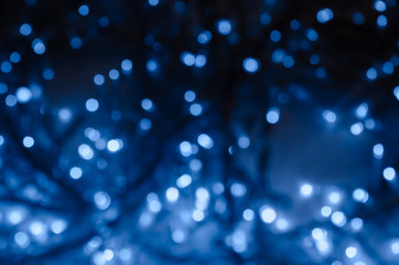 Abstract pattern of blue bokeh garland lights on a dark background