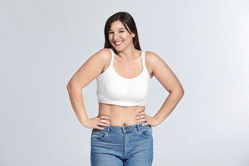 Young body positive woman on grey background