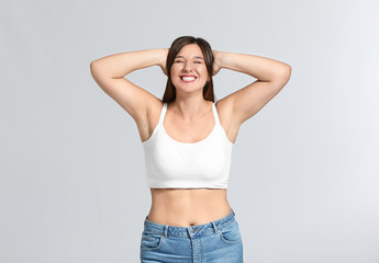 Young body positive woman on grey background