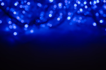 Abstract pattern of blue neon bokeh garland lights on a dark background
