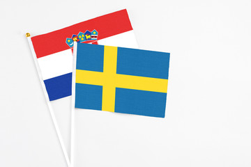 Sweden and Croatia stick flags on white background. High quality fabric, miniature national flag. Peaceful global concept.White floor for copy space.