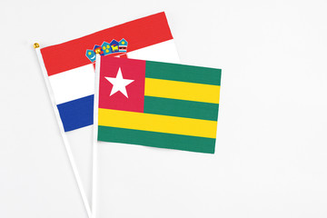 Togo and Croatia stick flags on white background. High quality fabric, miniature national flag. Peaceful global concept.White floor for copy space.