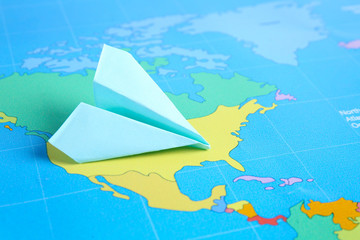 Origami airplane on world map