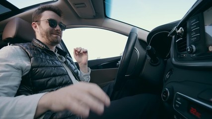 Cheerful man sits in a car during autoparking.